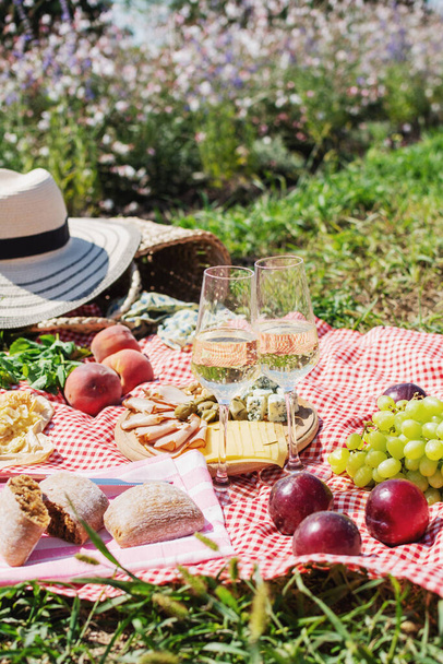 Zomer picknick in het park op het gras. Wijn, fruit en croissants - Foto, afbeelding