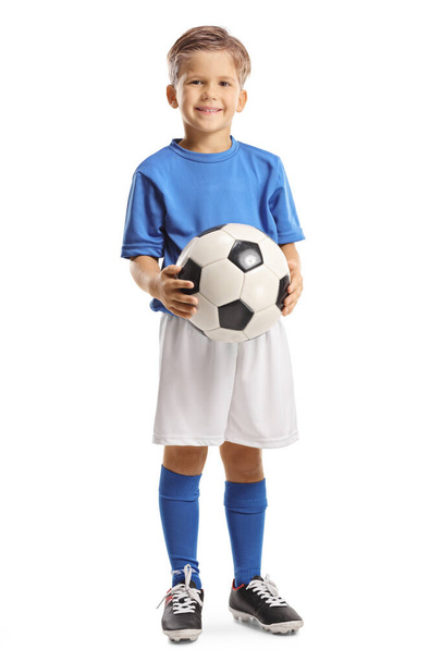 Cute little boy holding a soccer ball and smiling at camera isolated on white background - Zdjęcie, obraz