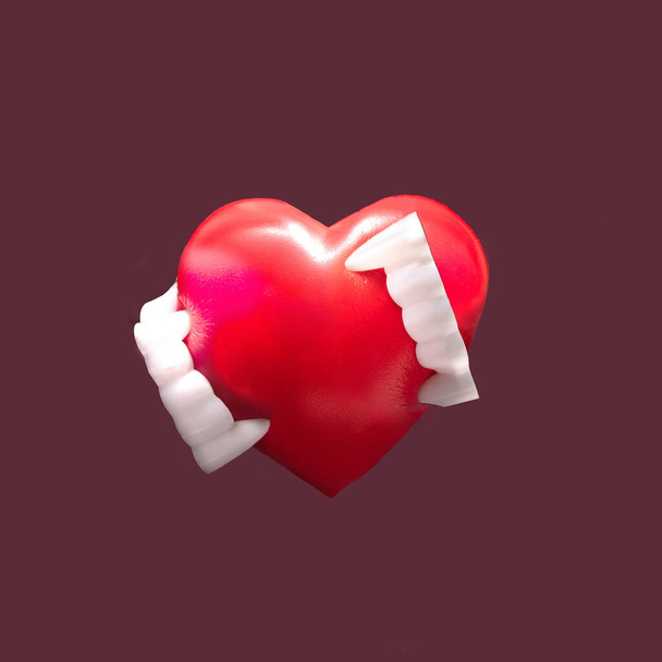 Вражаюча композиція з зубів вампіра кусає червоне серце. Мінімальний фон сливи
. - Фото, зображення