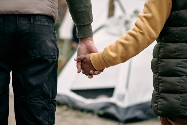 移民キャンプに対する子供の手を握る - 写真・画像