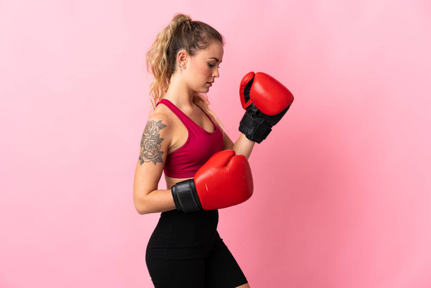 若いブラジルの女性は、ボクシングの手袋でピンクの背景に隔離 - 写真・画像