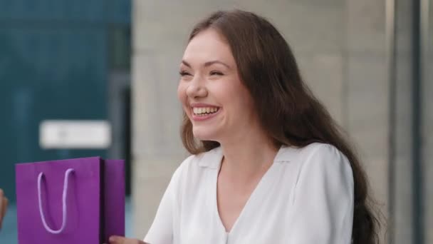 Young caucasian girl woman exited lady receiving purple package gift bag from unknown person looking inside present feeling frustrated dissatisfaction pretending happy lying about pleasure says thanks - Footage, Video