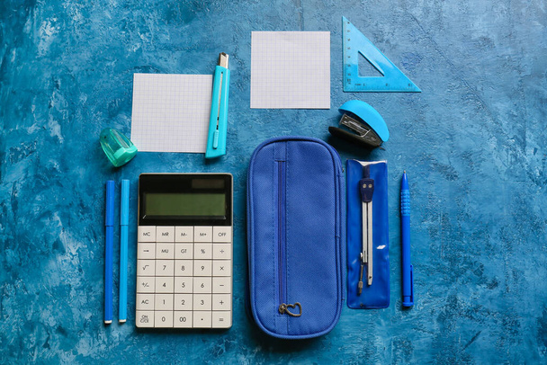 Piórnik, kalkulator i papeteria na kolorowym tle - Zdjęcie, obraz