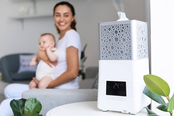Modern humidifier in room with mother and her baby - Фото, зображення