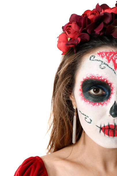 Young woman with painted skull on her face against white background. Celebration of Mexico's Day of the Dead (El Dia de Muertos) - Photo, Image
