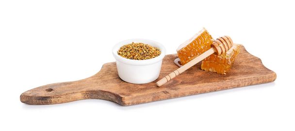 Bowl of bee pollen and honey combs on white background - Valokuva, kuva