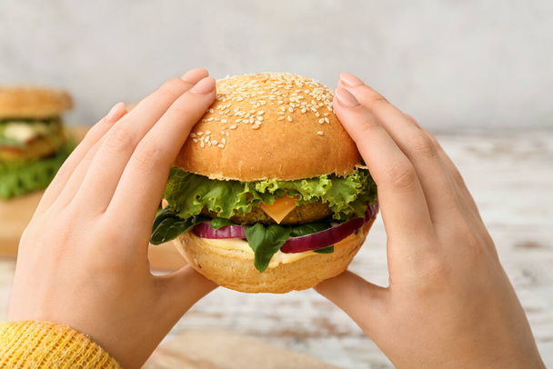 Woman holding tasty vegetarian burger - 写真・画像