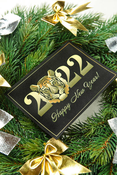 Tarjeta de felicitación para la celebración de Año Nuevo 2022 y corona de coníferas sobre fondo blanco, primer plano - Foto, Imagen