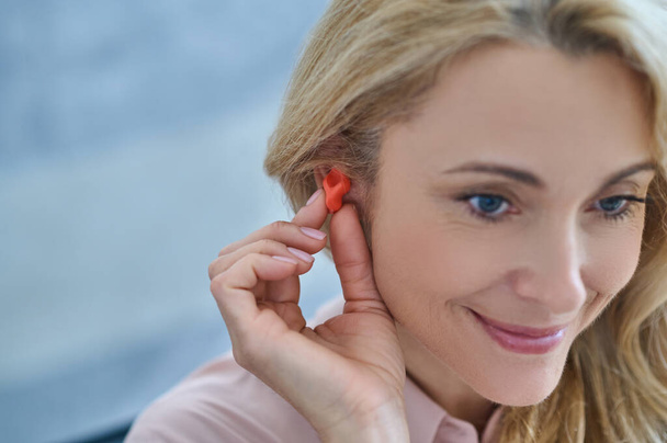 Smiling woman with hearing aid near ear - Fotó, kép