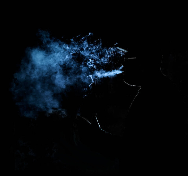 silhouette of  man smoking  cigarette on black   background - Фото, изображение
