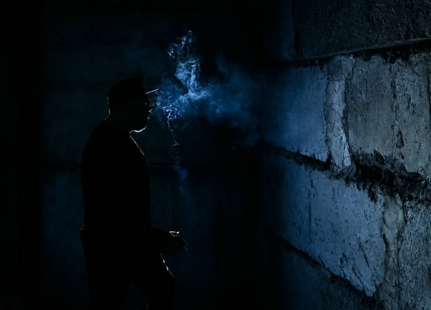 silhouette of  man smoking  cigarette on dark    background - Foto, Bild