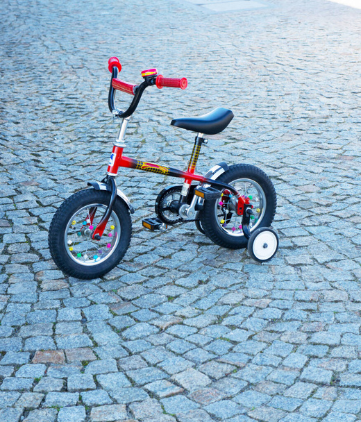 POZNAN, POLAND - Mar 26, 2014: A small children bicycle standing on a footpath in Poznan, Poland - Valokuva, kuva