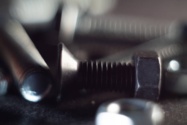 A closeup of the bolts and screws on dark background. - Φωτογραφία, εικόνα