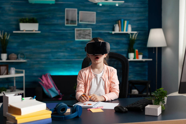 Kleines Schulkind mit Virtual-Reality-Headset genießt das Spielen mit der VR-Brille - Foto, Bild