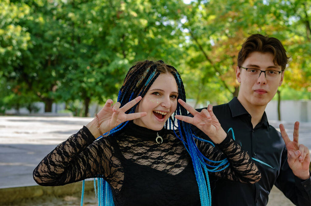 Ein junges Paar zeigt Siegergesten mit den Händen gegen - Foto, Bild