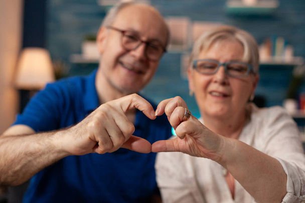 Senioren paar creëren hart vorm figuur met de handen - Foto, afbeelding