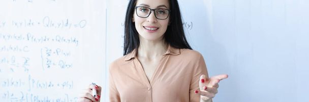 Porträt einer Lehrerin mit Brille in der Nähe der Schultafel - Foto, Bild