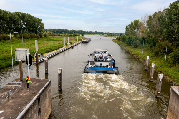 A boat sails through the sluice at the river 'the Maas" in the city of Roermond, province of Limbug, in the Netherlands - Fotografie, Obrázek