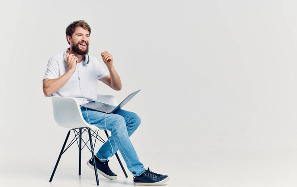 bearded man sitting on a chair with a laptop on his lap technology - Фото, зображення