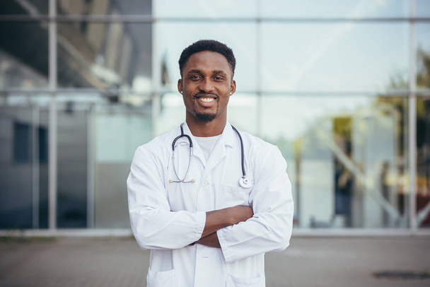 Portrait of an African doctor looking at camera and smiling in front of clinic - Fotó, kép