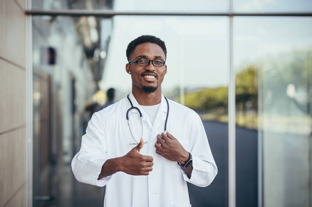 Portrait of an African doctor looking at camera and smiling in front of clinic - Foto, Imagen