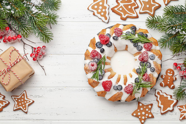 Pastel de Navidad con bayas y galletas de jengibre. Vista superior plano con espacio para sus saludos - Foto, Imagen
