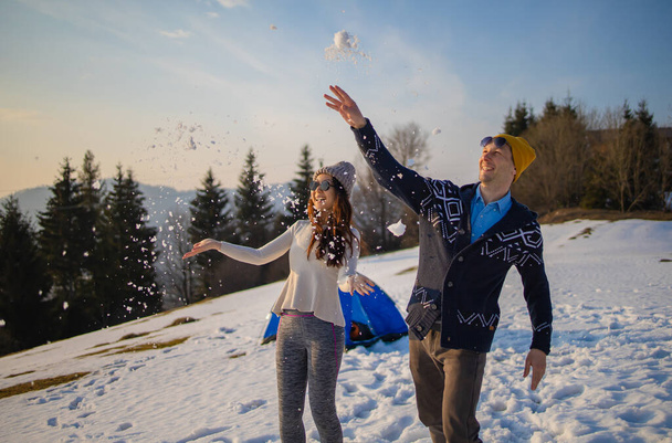 Pareja joven de raza mixta divirtiéndose en la nieve en vacaciones de invierno - Foto, Imagen