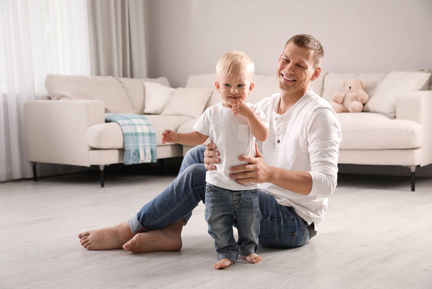 Father with his cute little son in living room - 写真・画像