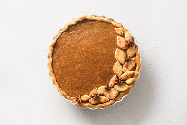 Homemade tasty pumpkin pie with autumn decorations and leaves for Thanksgiving Day on white. - Foto, Imagen