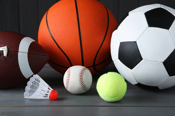 Set of different sport balls and shuttlecock on grey wooden table, closeup - Foto, Imagem