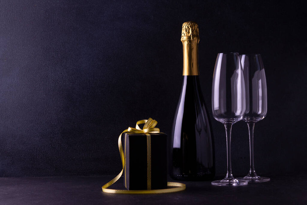 butelka szampana ze szklankami i pudełkiem prezentów - Zdjęcie, obraz