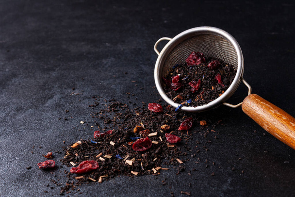 black tea and dry leaves on a wooden background - Φωτογραφία, εικόνα