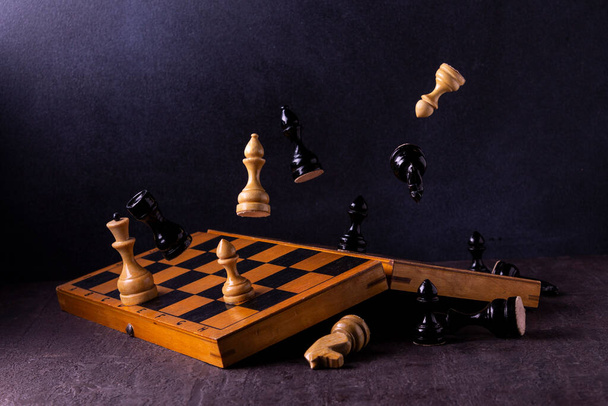 šachovnice s figurkami krále a královny na černém pozadí - Fotografie, Obrázek