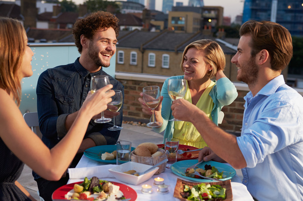 Group Of Friends Eating Meal On Rooftop Terrace - Foto, Imagem