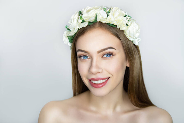 Close-up portrait of beautiful girl pretty lady with professional wedding makeup, hair styling. Luxury new beige color make-up, shiny pink lipstick glossy cosmetics. Flowers roses, conceptual idea - Photo, image