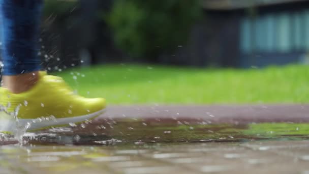Sportlerinnen joggen im Freien, treten in Pfützen. Ein einzelner Läufer läuft im Regen und macht Spritzer. Zeitlupe - Filmmaterial, Video