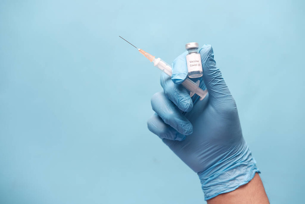 hand in latex gloves holding glass ampoule vaccine, with copy space  - Fotografie, Obrázek
