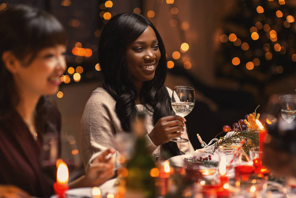 šťastní přátelé pití vína na vánoční párty - Fotografie, Obrázek