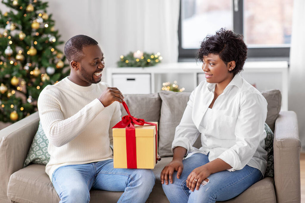 happy african couple with christmas gift at home - Fotoğraf, Görsel