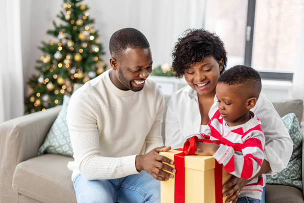 african family opening christmas gift at home - Foto, imagen