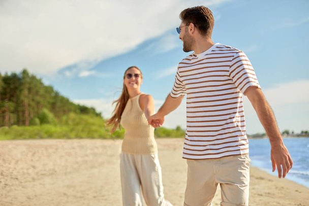 happy couple walking along summer beach - Fotografie, Obrázek