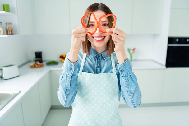 Photo portrait woman in apron childish looking in paprika slices smiling - Foto, Imagem