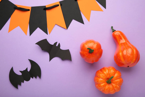 Halloween composition with bats and pumpkins on purple background. View from above. Top view - Фото, зображення
