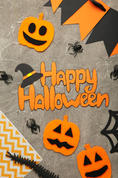 Halloween composition with bats and pumpkins on grey background. Top view. Vertical photo. - Zdjęcie, obraz