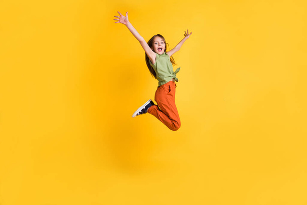 Full length body size photo little girl jumping up cheerful isolated vibrant yellow color background - Fotoğraf, Görsel