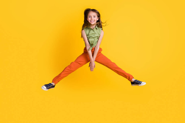 Full size photo of funny blond little girl jump wear blouse trousers isolated on yellow color background - Foto, immagini