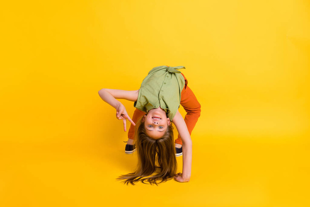 Foto de cuerpo completo de niña rubia loca hacer deporte usar pantalones de blusa aislados en el fondo de color amarillo - Foto, Imagen