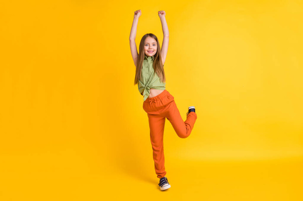 Full length body size photo little girl wearing casual clothes smiling isolated vivid yellow color background - Foto, Imagen