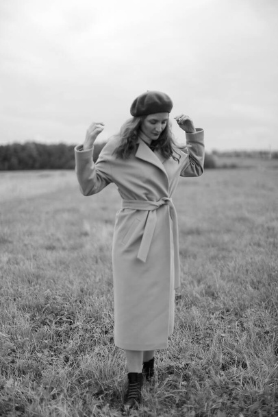 feminine girl in a beret and coat, autumn photo walk in nature , black and white aesthetics, fuzzy background, filmed - Foto, Imagem