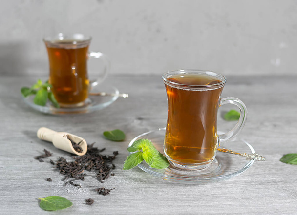 Two Turkish cups of tea stand on a light wooden table - Foto, imagen